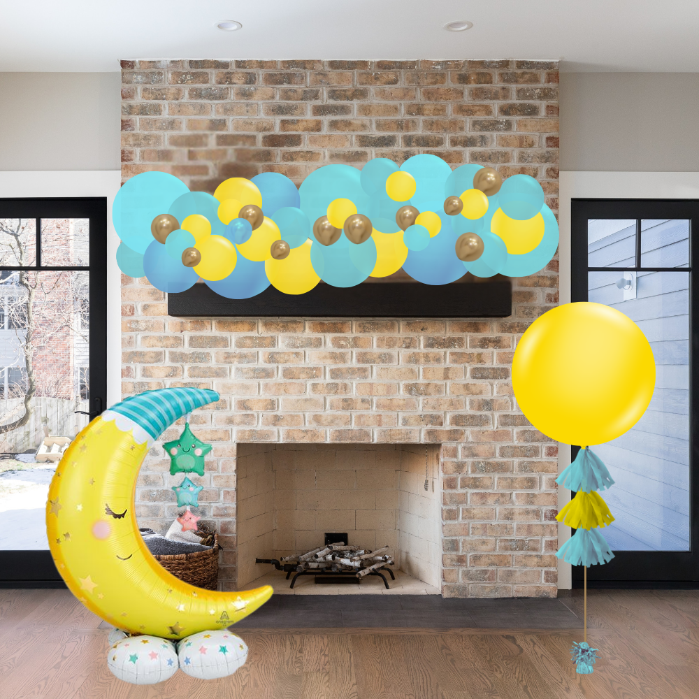Decorative balloon arch with yellow, blue, and green balloons above a fireplace.