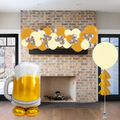 Decorative balloons and a large inflatable beer mug in front of a brick fireplace.