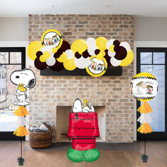 Decorative setup with Snoopy and Woodstock figures and balloons in a room with a brick wall.