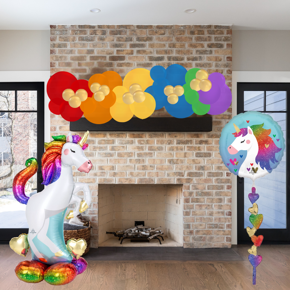 Colorful unicorn balloons in front of a brick fireplace.