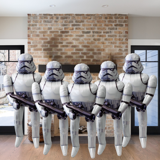 Five inflatable stormtrooper figures in a living room setting with a brick wall.