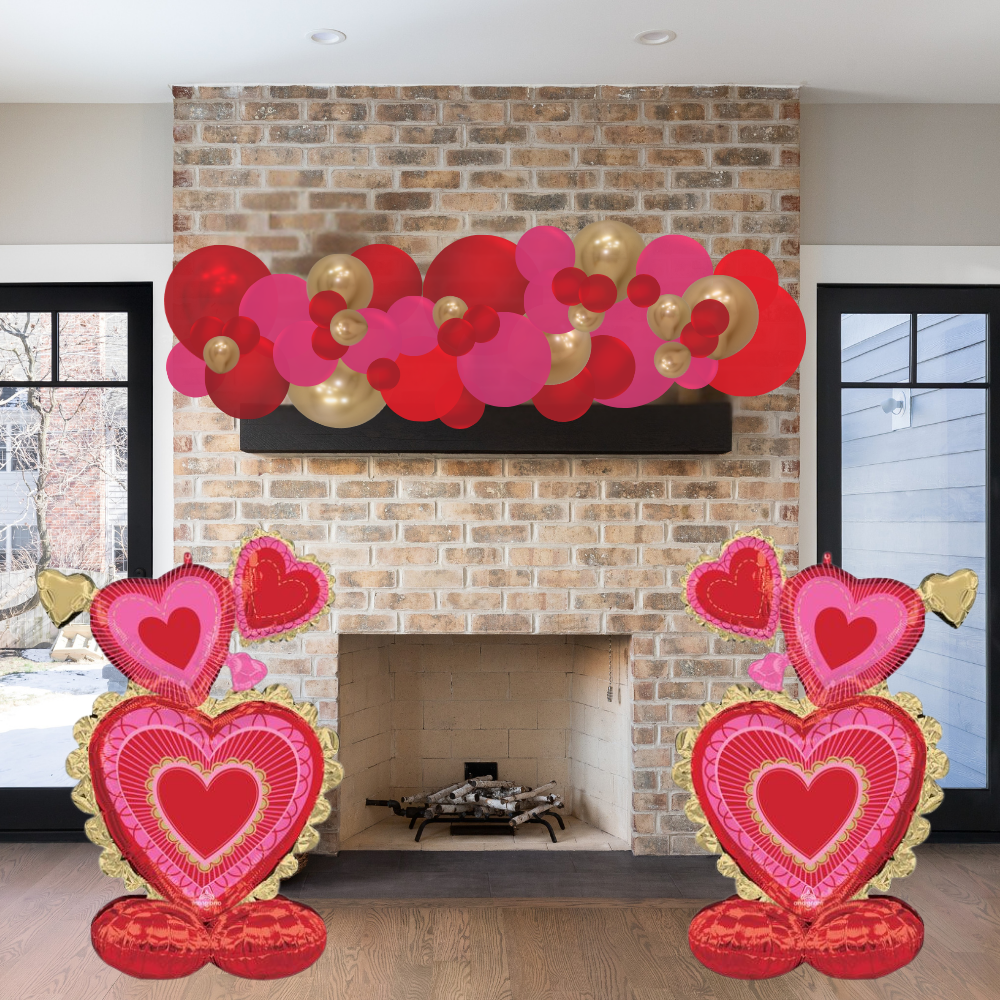 Decorative heart-shaped balloons in front of a brick fireplace.