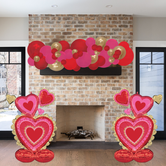 Decorative heart-shaped balloons in front of a brick fireplace.