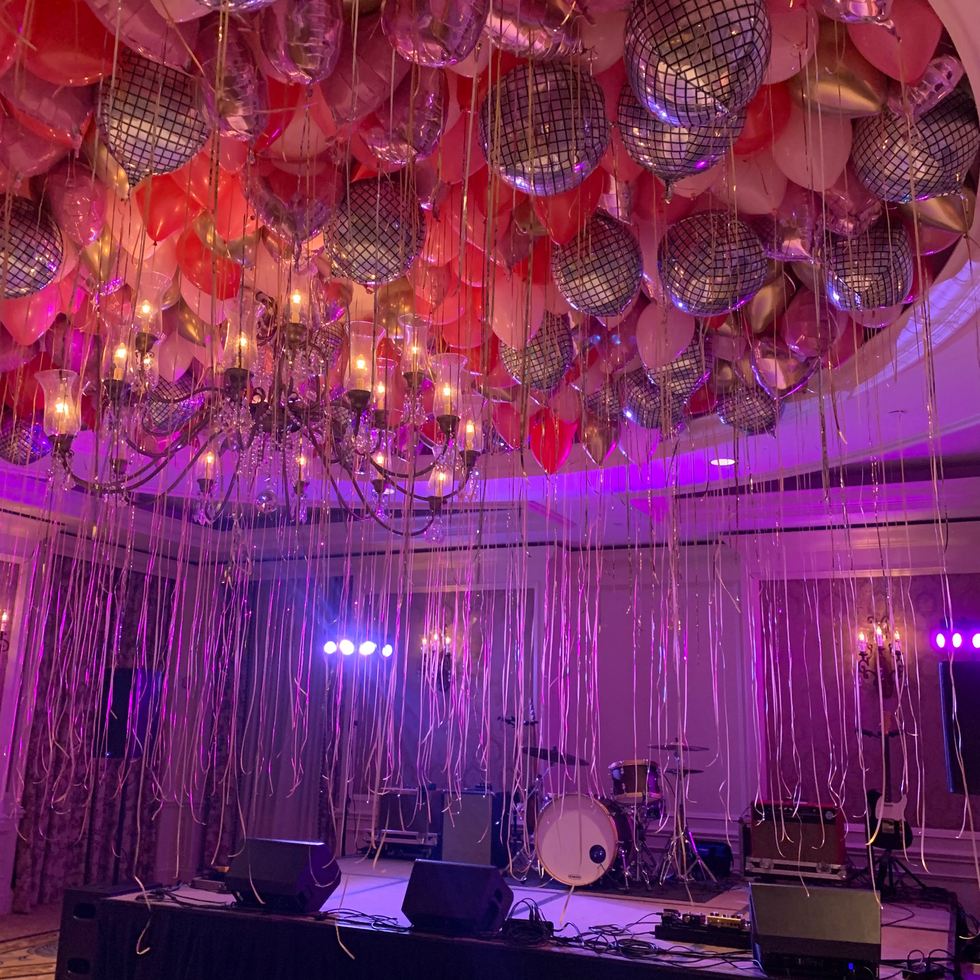ceiling filled with pink balloons and disco ball balloons